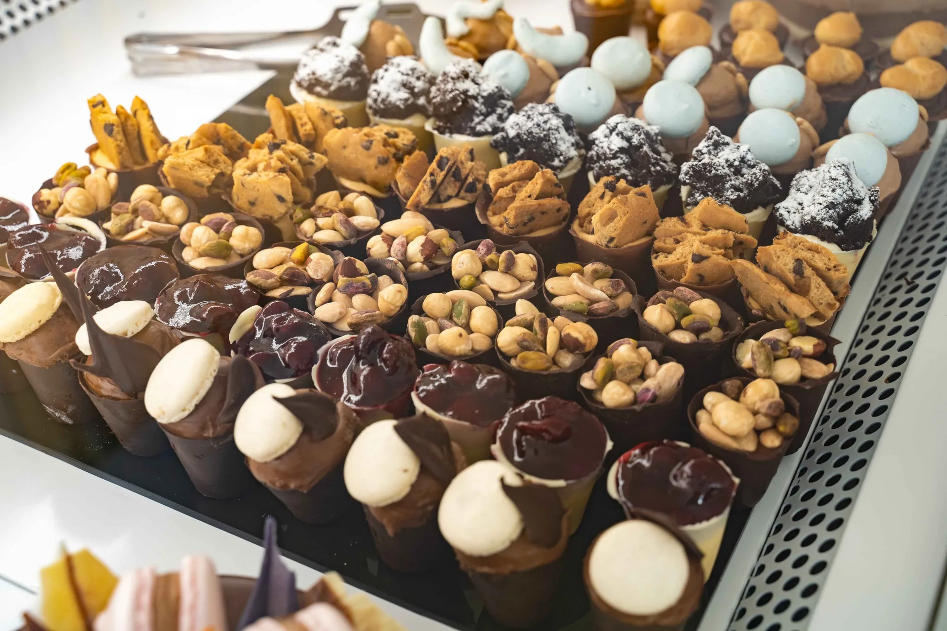 Dessert table spread with assorted mini pastries, cones and sweet bites by Epoca Patisserie